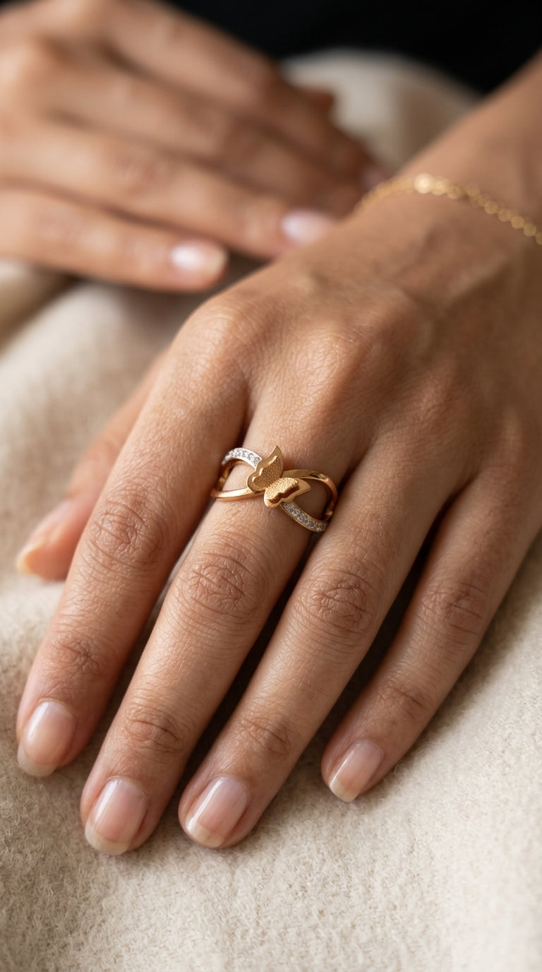 Close-up of a hand wearing a gold ring on a neutral background