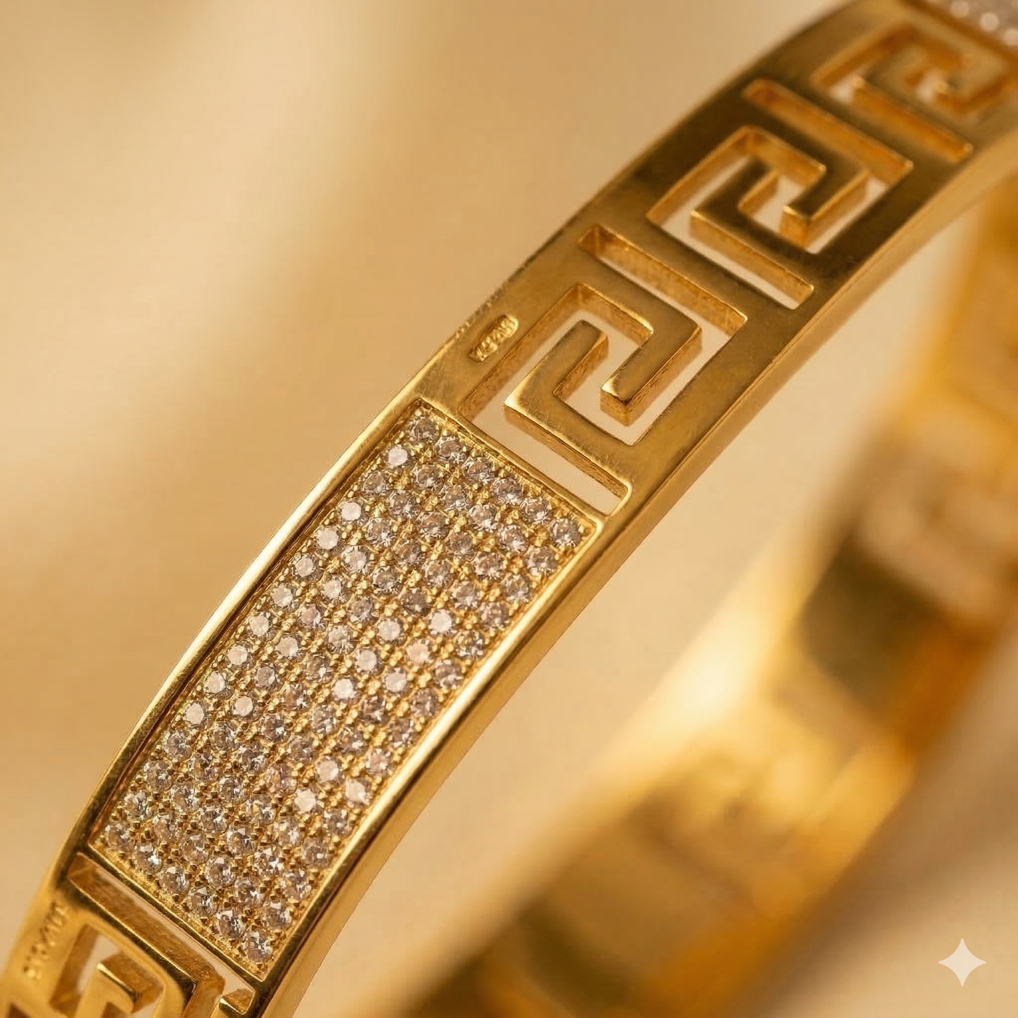 Gold bracelet with diamond-studded section and intricate design on a gold background