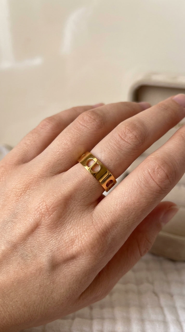 Gold ring on a person's finger with a neutral background