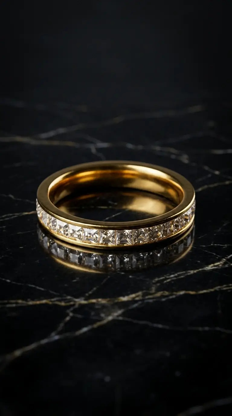 Gold ring with diamond accents on a dark marble surface