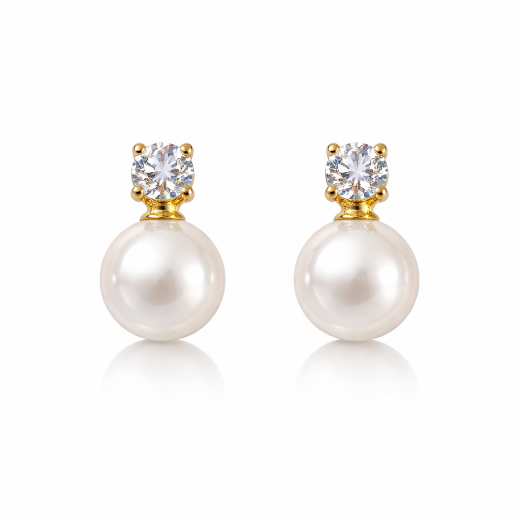 Pearl earrings with gold and clear gemstones on a white background