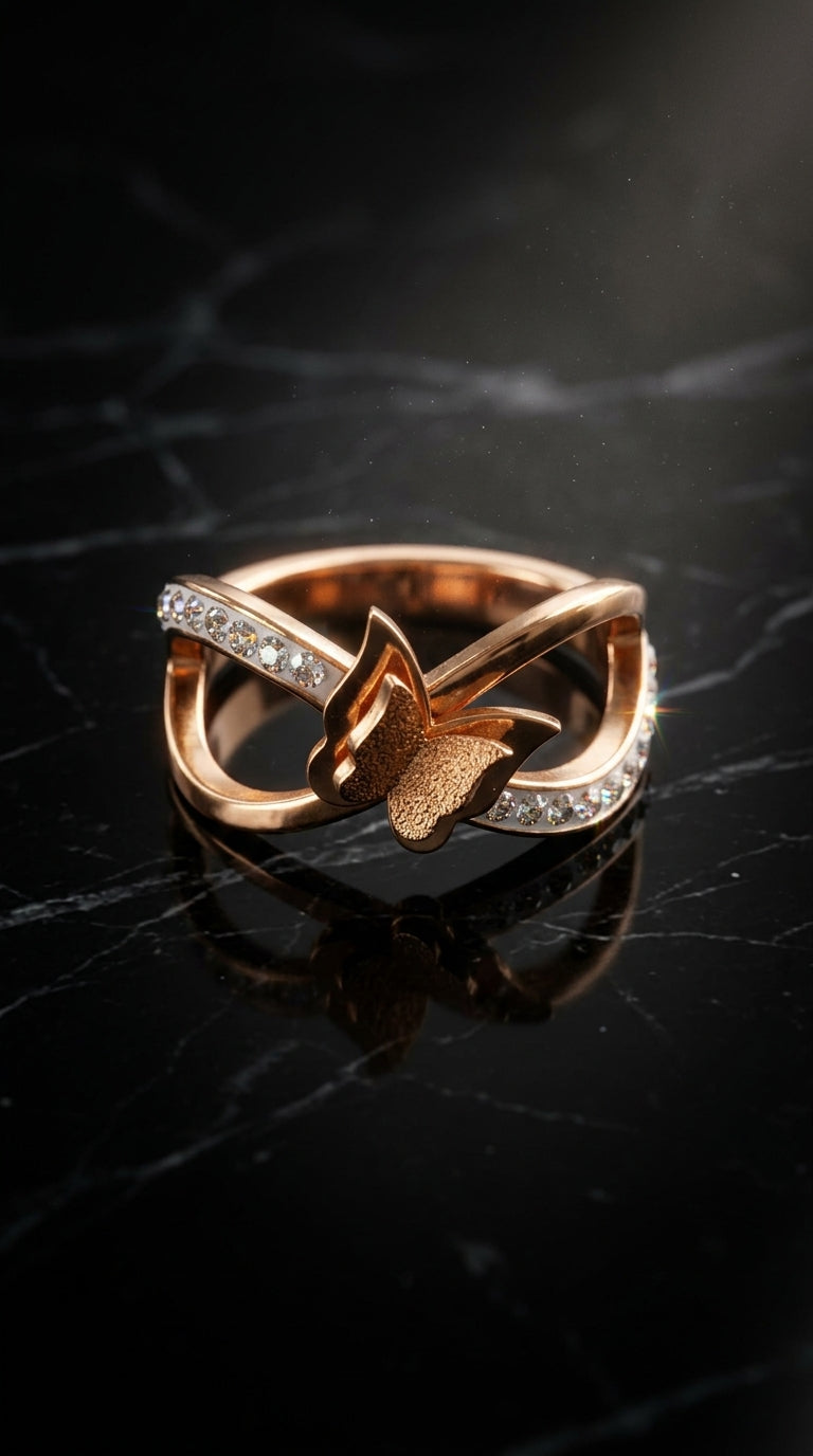 Rose gold ring with butterfly design on a black marble surface