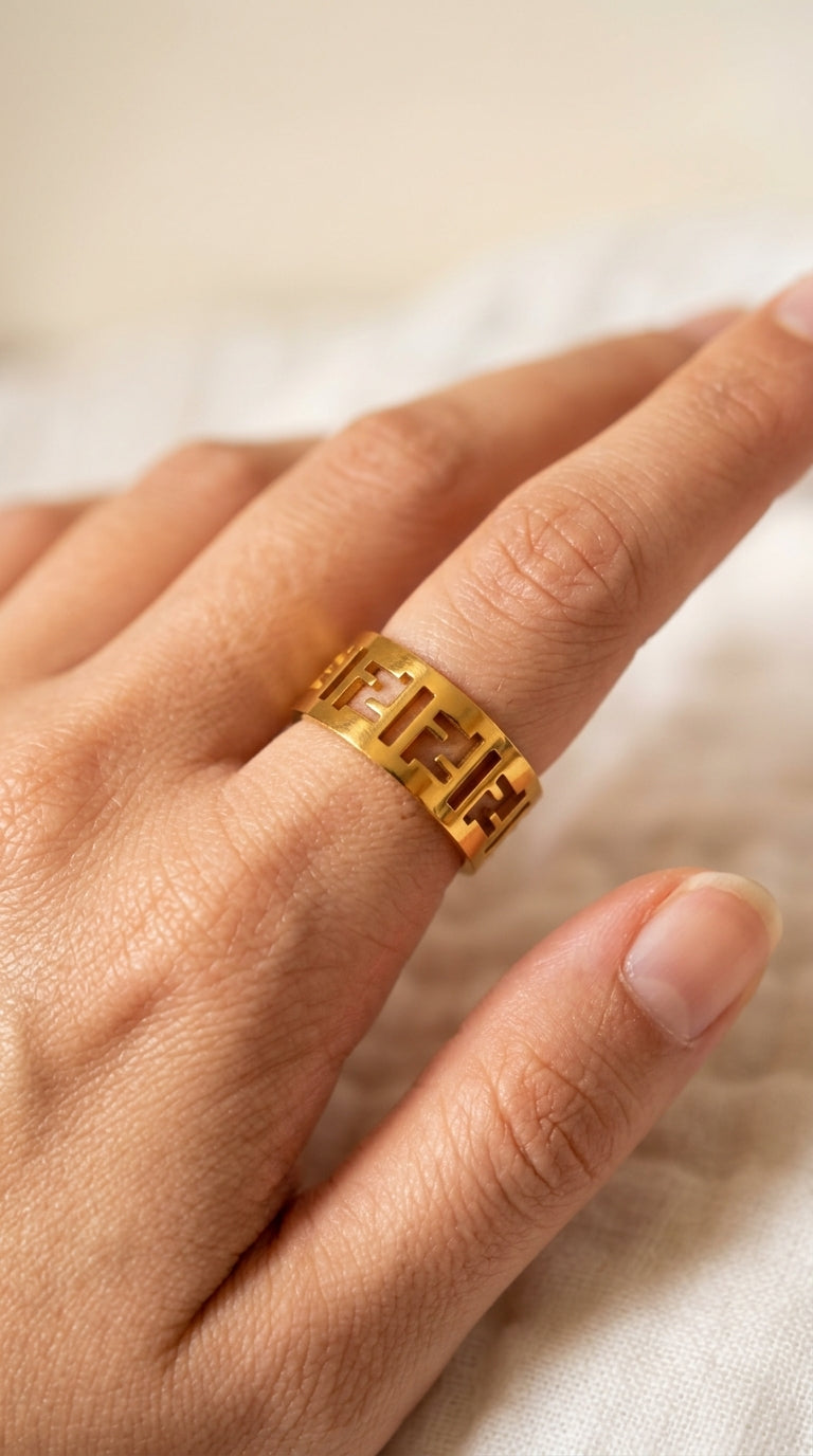 Gold ring on a person's finger against a neutral background